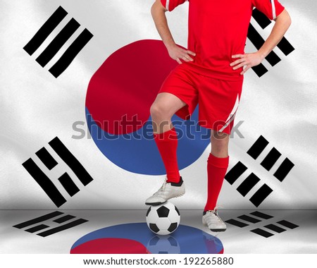 Handsome football player looking at camera against korea republic national flag