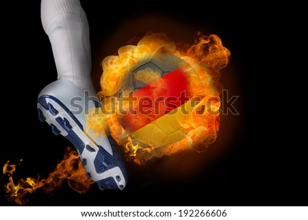 Football player kicking flaming germany ball against black