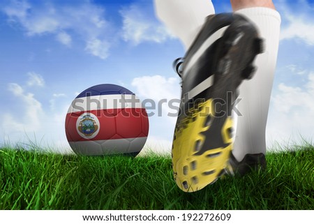 Composite image of football boot kicking costa rica ball against field of grass under blue sky