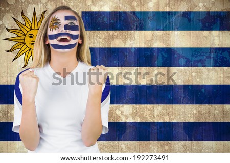Excited fan in uruguay face paint cheering against uruguay flag in grunge effect