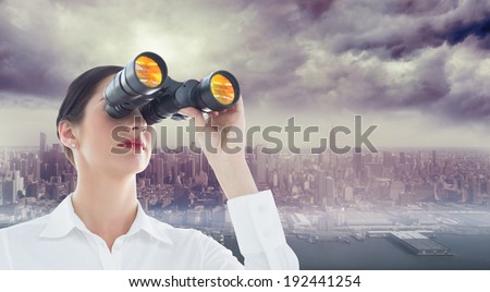 Business woman looking through binoculars against coastline and city