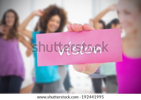 Fit blonde holding card saying vision against fitness class in gym