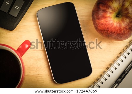 Overhead of smartphone screen on a cluttered desk
