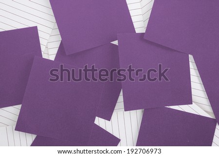 Purple paper strewn over notepad paper