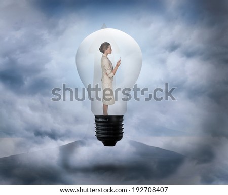 Thinking businesswoman in light bulb against road turning into arrow