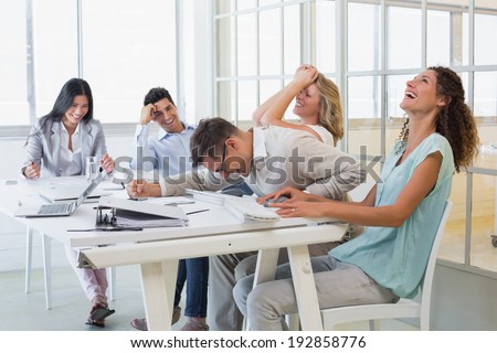 Casual business team laughing during meeting in the office