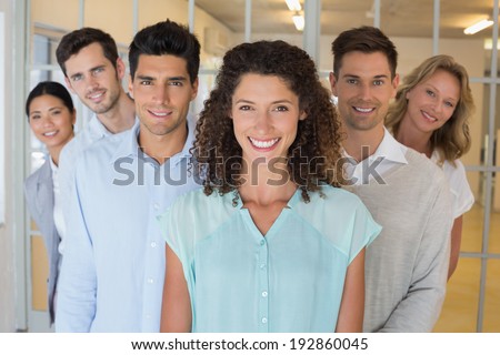 Casual happy business team smiling at camera together in the office