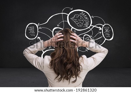 Young classy businesswoman with hands on head standing back to camera against black wall