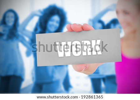 Fit blonde holding card saying work against fitness class in gym