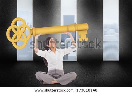 Businesswoman sitting cross legged carrying large key against graphic with doors and a light bulb on gloomy countryside