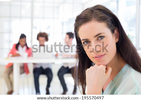 Attractive office worker thinking and looking at camera in the office