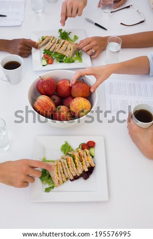 Workers eating healthy lunch during meeting in the office