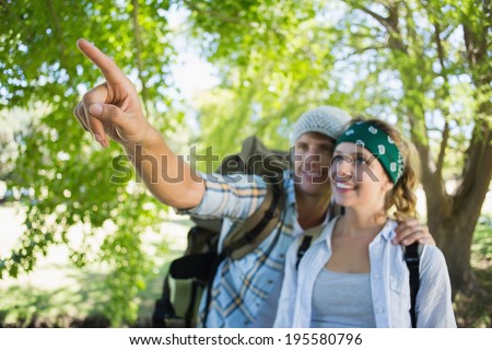 Active couple on a hike with man pointing on a sunny day
