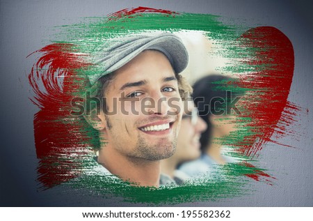 Composite image of smiling designer with red and green paint against digitally generated grey vignette background