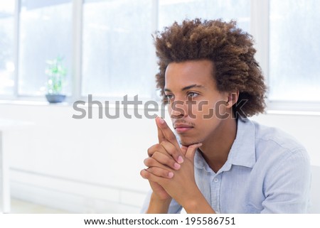 Attractive businessman thinking with hands together in the office
