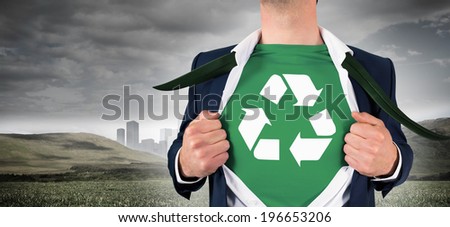 Businessman opening shirt in superhero style against cityscape in distance under cloudy sky