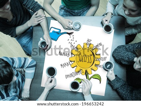 People sitting around table drinking coffee with page showing success sunflower doodle