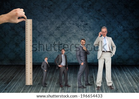 Composite image of hand measuring stages of businessmans life with ruler against dark grimy room