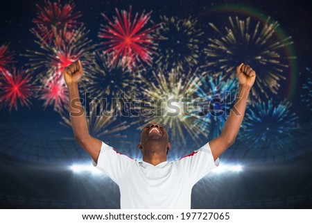 Excited handsome football fan cheering against fireworks exploding over football stadium