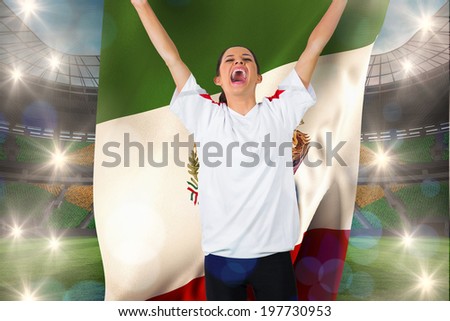 Football fan in white cheering holding mexico flag against large football stadium with brasilian fans