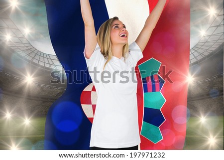 Pretty football fan in white cheering holding croatia flag against large football stadium with lights