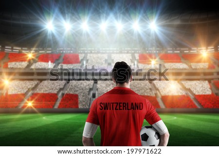 Swiss football player holding ball against stadium full of swiss football fans