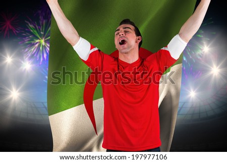 Excited football fan cheering against fireworks exploding over football stadium and algeria flag