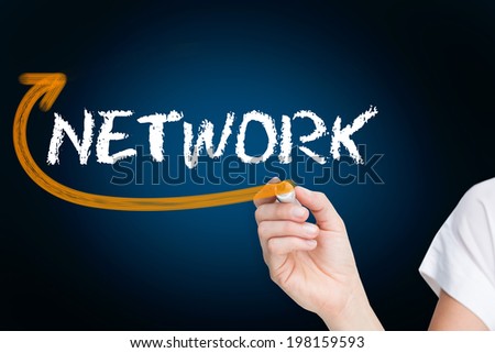 Businesswoman writing the word network against blue background with vignette