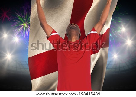 Excited handsome football fan cheering against fireworks exploding over football stadium and england flag