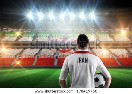 Iran football player holding ball against stadium full of iran football fans