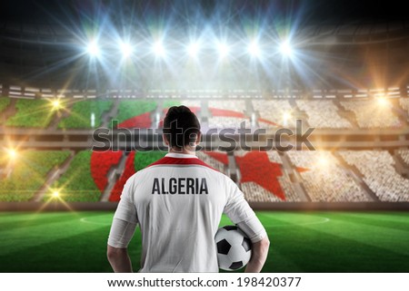 Algeria football player holding ball against stadium full of algeria football fans