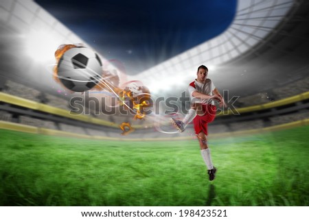 Football player in white kicking against football pitch in large stadium
