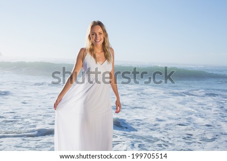 Pretty blonde at the beach in white sundress on a sunny day