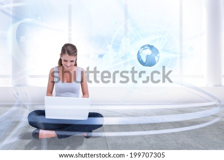 Cross legged woman using a laptop against bright room with window