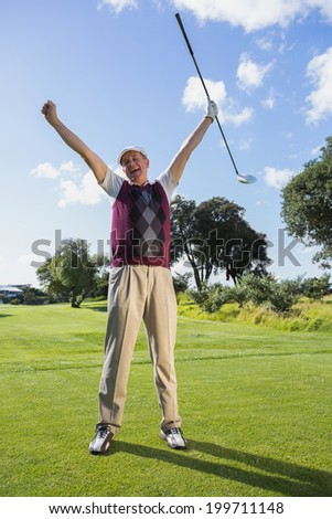 Excited golfer cheering and looking at camera on a sunny day at the golf course