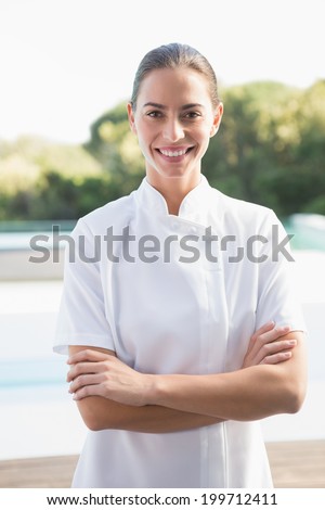Smiling beauty therapist looking at camera outside at the spa