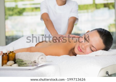 Content brunette getting a back massage at the spa