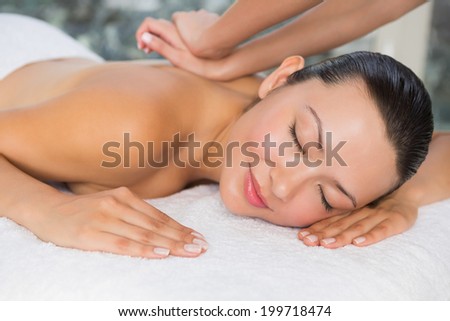 Content brunette enjoying a back massage at the health spa
