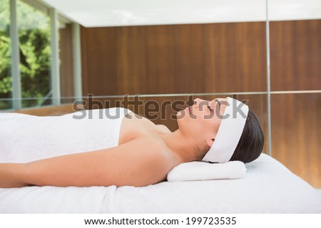 Peaceful brunette lying on massage table in the health spa