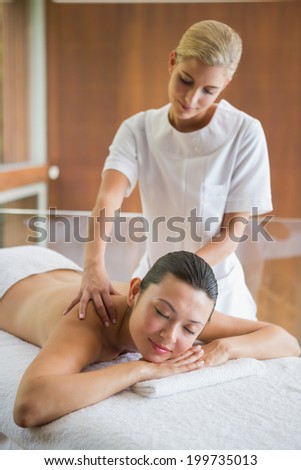 Brunette enjoying a peaceful massage at the health spa