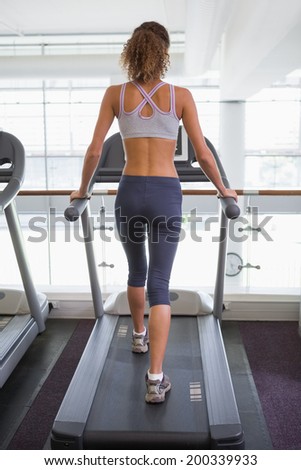 Fit woman walking on the treadmill at the gym