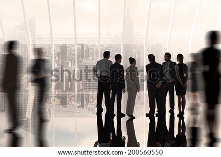 Composite image of business colleagues standing against room with large window looking on city