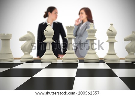 Composite image of businesswomen and chess pieces against white background with vignette