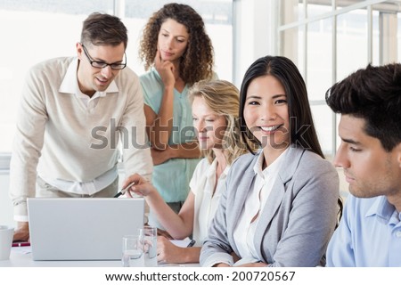 Casual businesswoman smiling at camera during meeting in the office