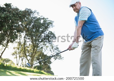 Golfer holding his golf club on a sunny day at the golf course