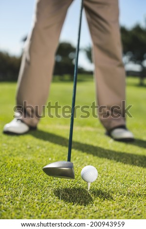 Golfer about to tee off on a sunny day at the golf course