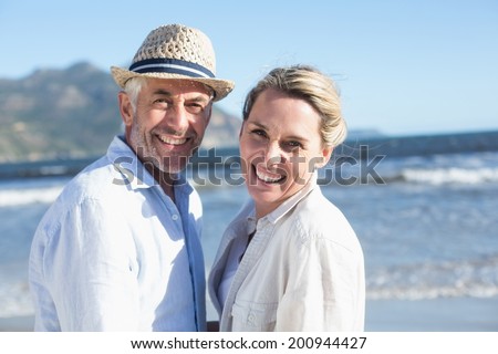 Happy couple standing on the beach together on a sunny day