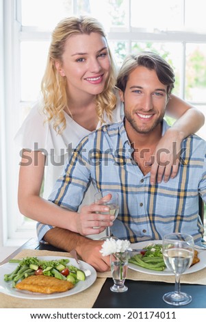Cute smiling couple enjoying a meal together at home in the dining room
