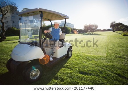 Golfer reversing his golf buggy on a sunny day at the golf course