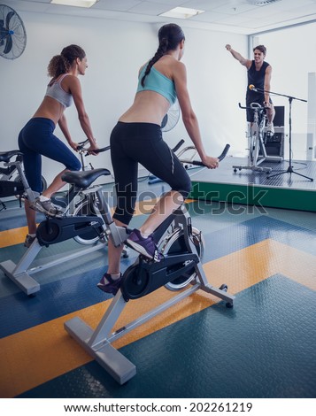Spin class working out with motivational instructor at the gym